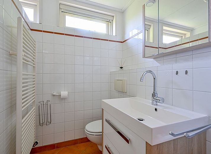 Der Bungalow Slufterhoek 108 in De Cocksdorp, Texel, bietet eine sonnige Terrasse und einen grossen Garten, ideal fuer einen erholsamen Urlaub auf den Watteninseln.