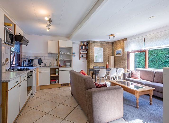 Gemuetliches Wohnzimmer des Ferienhauses Slufterduin 092 in De Cocksdorp, Texel mit bequemen Sofas und viel Tageslicht.