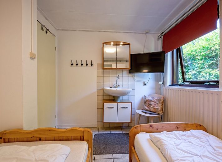 Gemuetliches Wohnzimmer des Ferienhauses Slufterduin 092 in De Cocksdorp, Texel mit bequemen Sofas und viel Tageslicht.