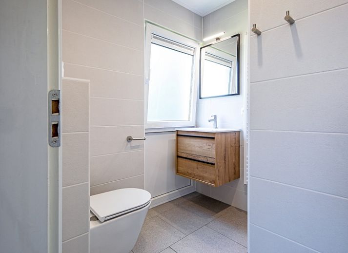 Cozy living room of Holiday home Slufterhoek 132 in De Cocksdorp, Texel with comfortable sofas and views of nature.