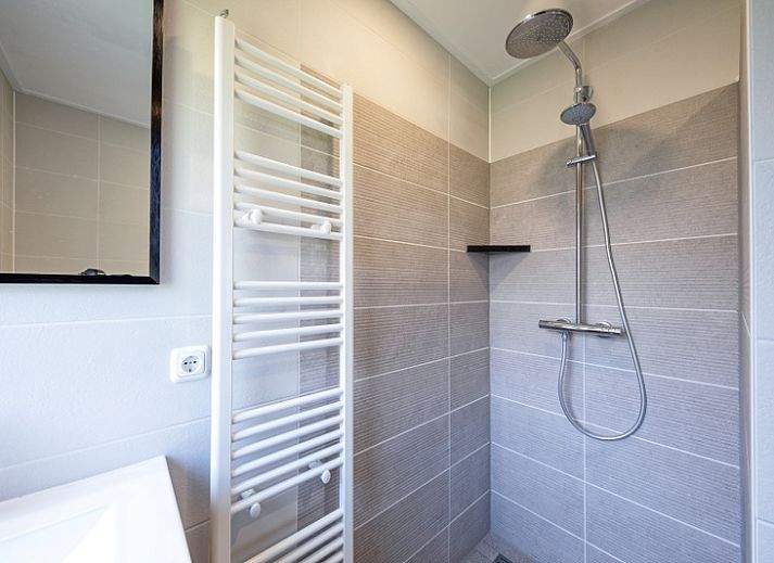 Cozy living room of Holiday home Slufterhoek 132 in De Cocksdorp, Texel with comfortable sofas and views of nature.