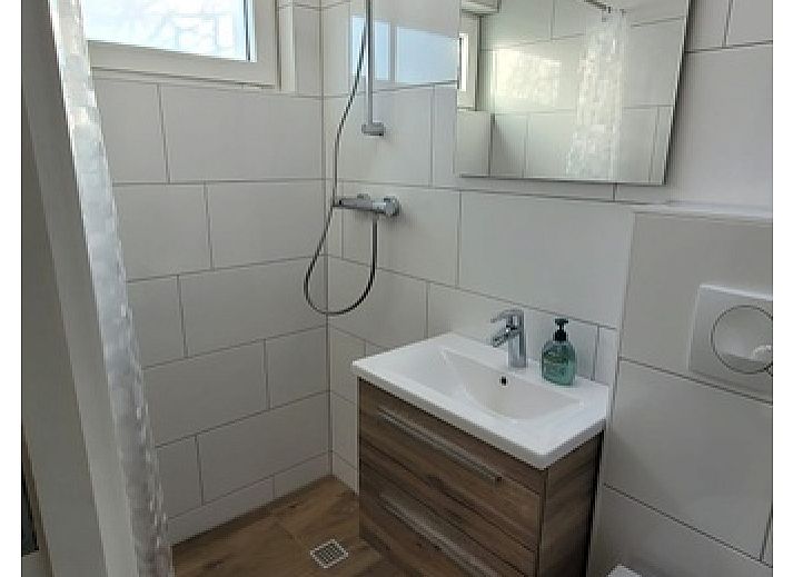 Lichte woonkamer van Bungalow Tamarisk 190 in De Cocksdorp Texel met comfortabele zithoek en uitzicht op de tuin.
