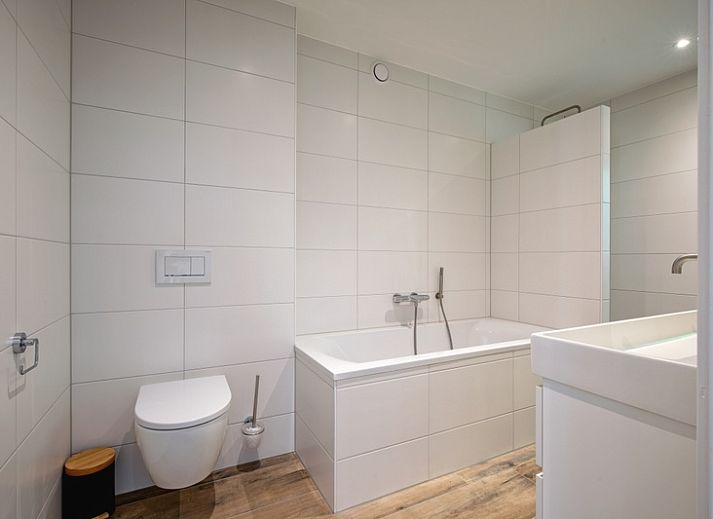 Gezellige woonkamer van Vakantiehuis Slufterhoek 104 in De Cocksdorp, Texel met comfortabele zitplaatsen en sfeervolle inrichting.