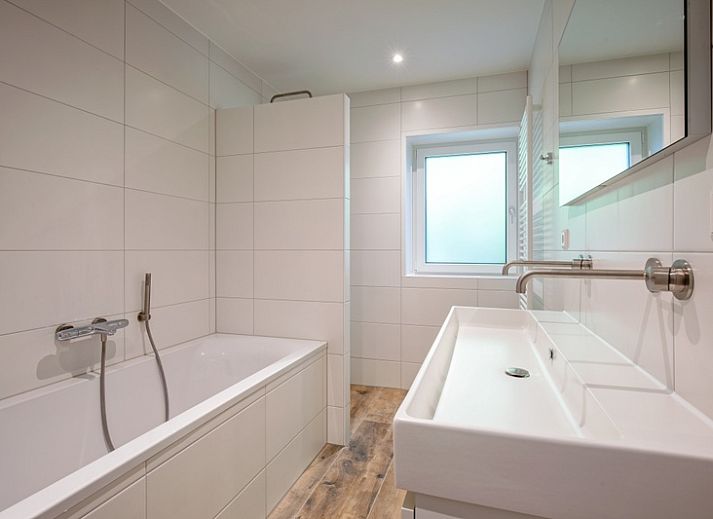 Gezellige woonkamer van Vakantiehuis Slufterhoek 104 in De Cocksdorp, Texel met comfortabele zitplaatsen en sfeervolle inrichting.