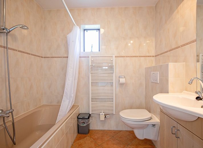 Gezellige woonkamer in Villapark Residentie Texel nr. 711, vakantiehuis in De Cocksdorp, Texel met moderne inrichting en grote ramen.