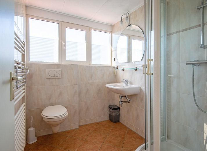 Gezellige woonkamer in Villapark Residentie Texel nr. 711, vakantiehuis in De Cocksdorp, Texel met moderne inrichting en grote ramen.