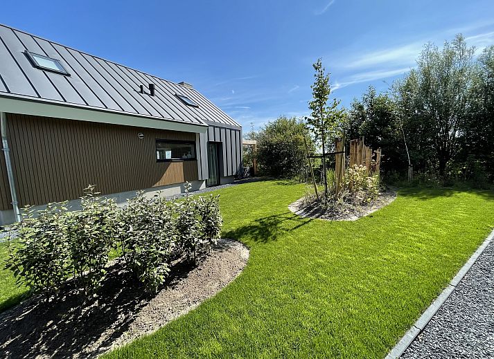 Helles Wohnzimmer eines freistehenden Hauses in De Cocksdorp, Texel. Gemtliche Essecke mit Blick auf die grne Umgebung der Waddeninseln.