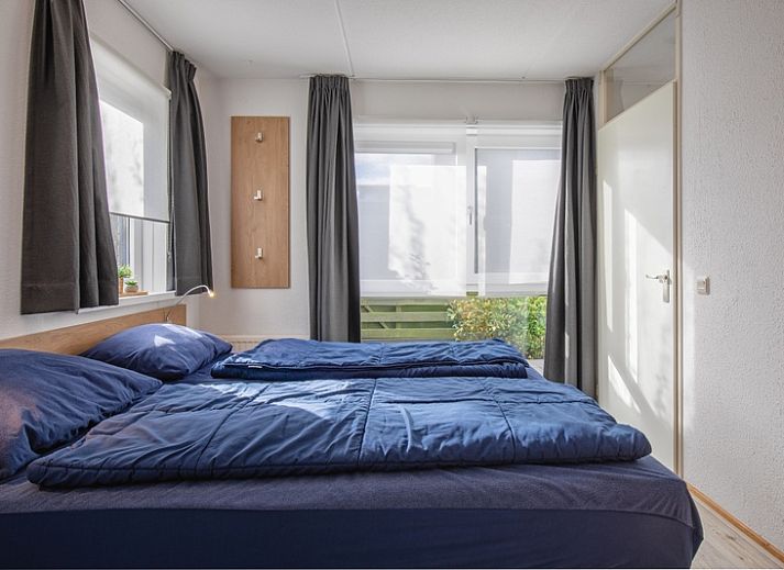 Gezellige woonkamer in Villapark Residentie Texel nr. 305, vakantiehuis in De Cocksdorp op Texel, met comfortabele zithoek en tuinzicht.