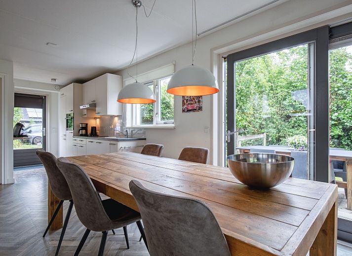 Blommetjes Buiten vakantiehuis in De Cocksdorp, Texel met groene tuin en houten gevel.