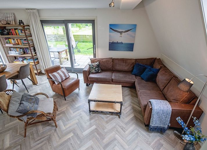 Blommetjes Buiten vakantiehuis in De Cocksdorp, Texel met groene tuin en houten gevel.