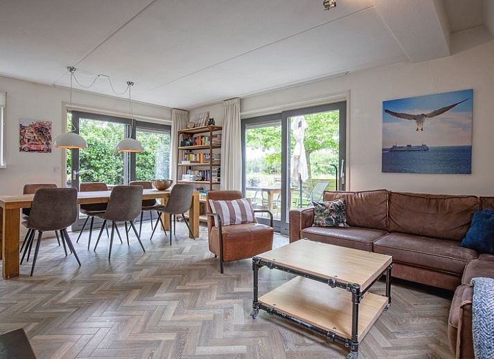 Blommetjes Buiten vakantiehuis in De Cocksdorp, Texel met groene tuin en houten gevel.