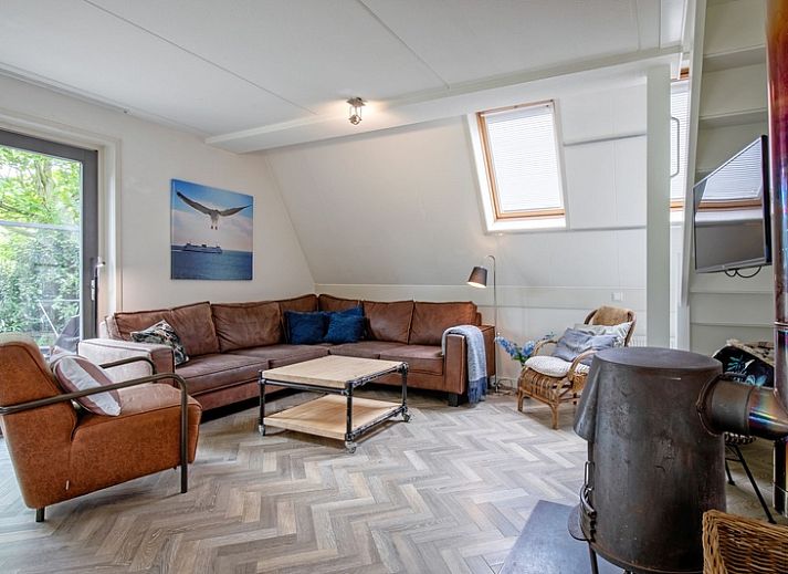 Moderne keuken en eetruimte in Blommetjes Buiten, De Cocksdorp, Texel met uitzicht op groene tuin.