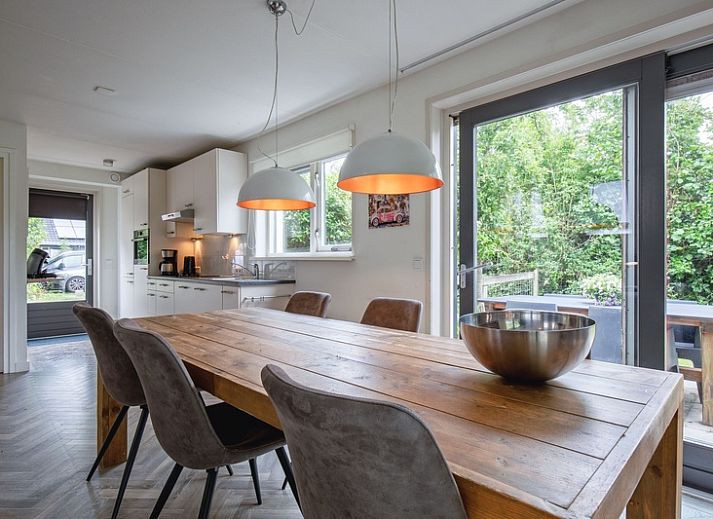 Moderne keuken en eetruimte in Blommetjes Buiten, De Cocksdorp, Texel met uitzicht op groene tuin.