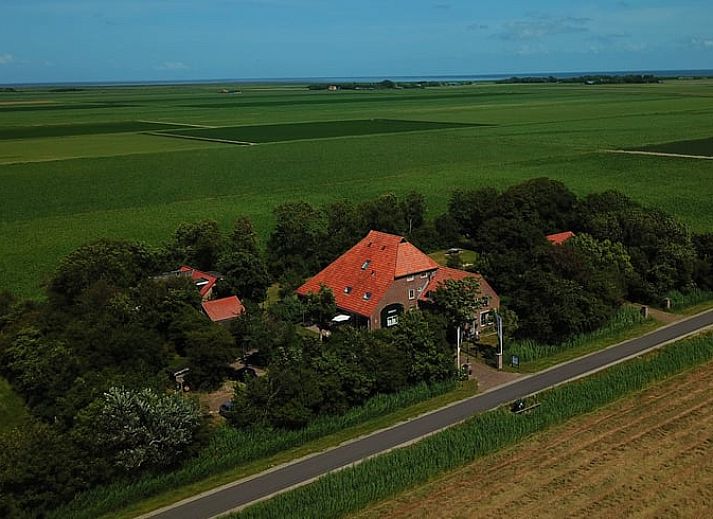 Vakantiehuisje in De Cocksdorp, Texel met charmante gevel en rode dakpannen, perfect voor een ontspannen verblijf op de Waddeneilanden.
