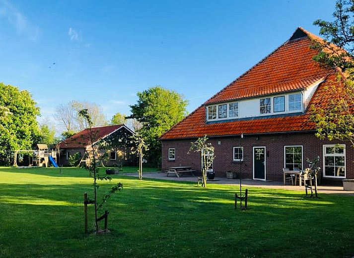 Entree van Vakantiehuisje in De Cocksdorp, Texel bij zonsondergang, verwelkomt gasten met een warme sfeer op de Waddeneilanden.