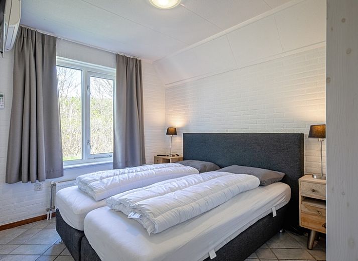 Gemuetliches Wohnzimmer des Ferienhauses Schelpenoord 135 in De Cocksdorp, Texel mit bequemen Sofas und viel Tageslicht.