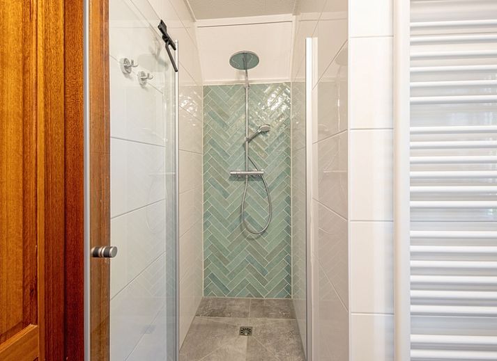 Gemuetliches Wohnzimmer des Ferienhauses Schelpenoord 135 in De Cocksdorp, Texel mit bequemen Sofas und viel Tageslicht.