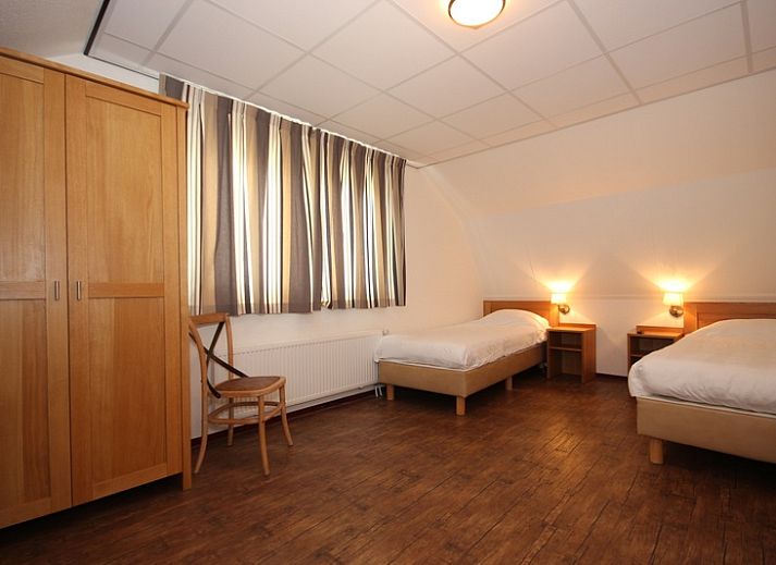 Gezellige woonkamer in Villa De Witte Hoek serre huisdiervrij, De Cocksdorp Texel, met comfortabele banken en een sfeervolle haard.