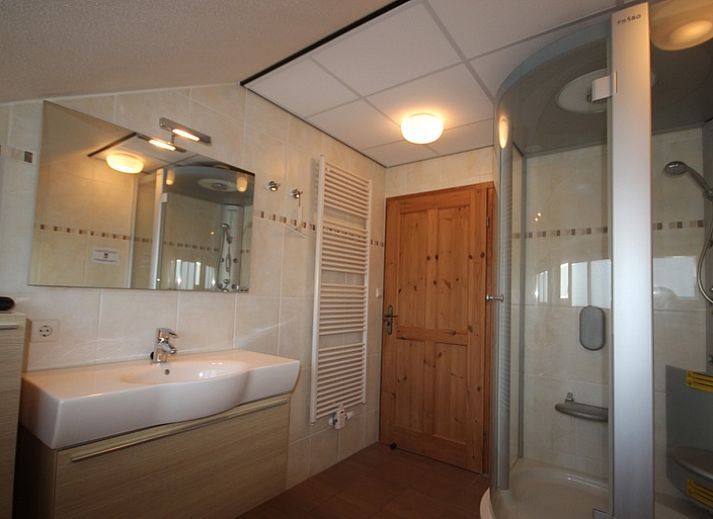 Gezellige woonkamer in Villa De Witte Hoek serre huisdiervrij, De Cocksdorp Texel, met comfortabele banken en een sfeervolle haard.