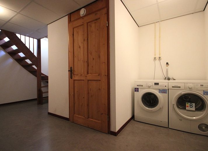 Gezellige woonkamer in Villa De Witte Hoek serre huisdiervrij, De Cocksdorp Texel, met comfortabele banken en een sfeervolle haard.