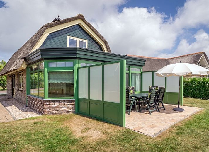 Gezellige woonkamer in Villa De Witte Hoek serre huisdiervrij, De Cocksdorp Texel, met comfortabele banken en een sfeervolle haard.