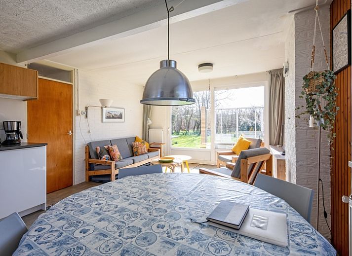 Lichte woonkamer van Vakantiehuis Slufteroord 292 in Bungalowpark Slufteroord, De Cocksdorp, Texel, met uitzicht op de tuin.