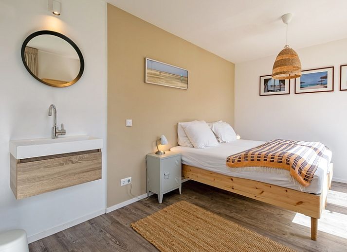 Lichte woonkamer van Vakantiehuis Slufteroord 292 in Bungalowpark Slufteroord, De Cocksdorp, Texel, met uitzicht op de tuin.