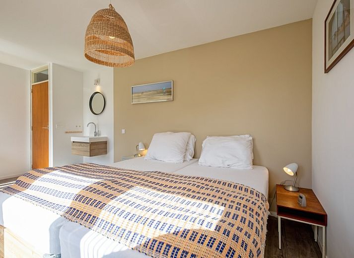 Lichte woonkamer van Vakantiehuis Slufteroord 292 in Bungalowpark Slufteroord, De Cocksdorp, Texel, met uitzicht op de tuin.