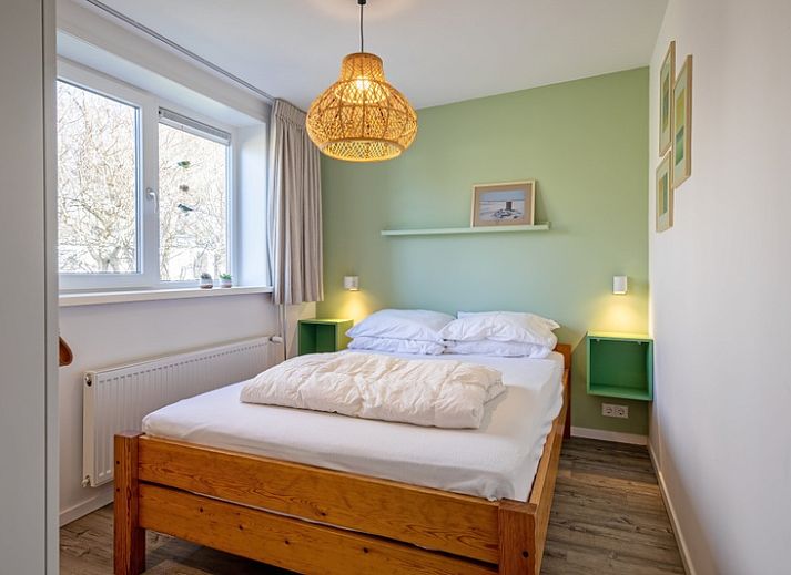 Lichte woonkamer van Vakantiehuis Slufteroord 292 in Bungalowpark Slufteroord, De Cocksdorp, Texel, met uitzicht op de tuin.