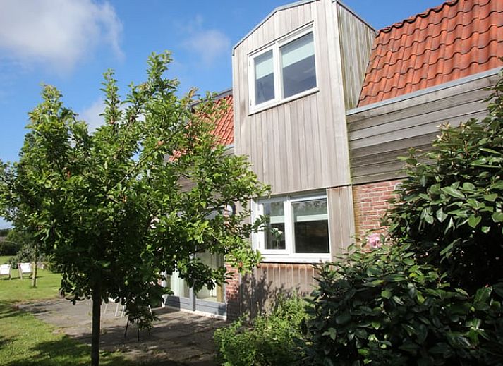 Exterieur van Vakantiehuis in De Cocksdorp, Texel, omgeven door groene natuur en een zonnige tuin, Waddeneilanden.