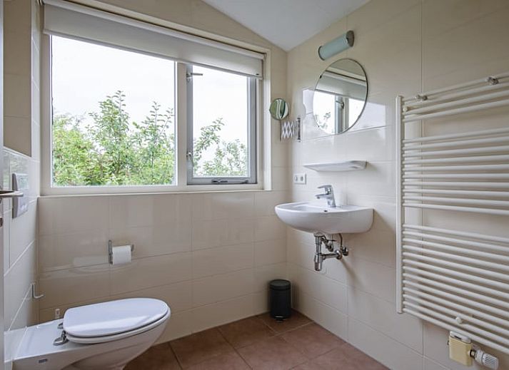 Vakantiehuis in De Cocksdorp op Texel, Waddeneilanden, omgeven door groene natuur en een uitnodigend terras.