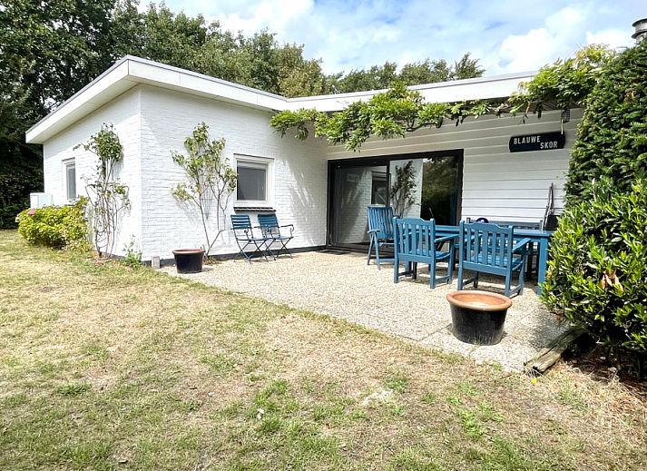 Geniet van de rust bij Bungalow Slufterduin - De Blauwe Skor in De Cocksdorp, Texel, met een uitnodigend terras te midden van groene natuur.