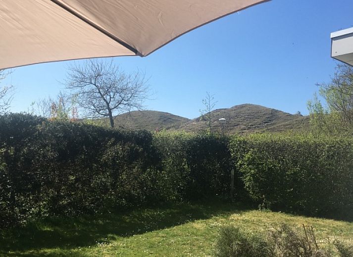 Ontspan op het terras van Bungalow Slufterduin - De Blauwe Skor in De Cocksdorp, Texel, omgeven door groene natuur en rust.