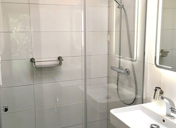 Bungalow Slufterduin - De Blauwe Skor in De Cocksdorp, Texel, met terras en paarse bloemen voor een ontspannen vakantiehuiservaring.