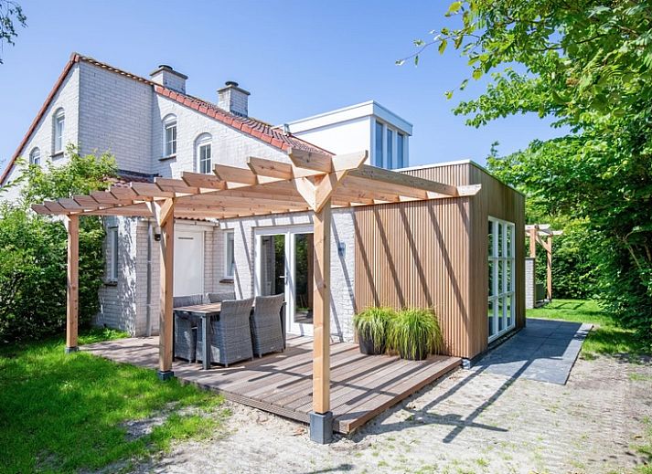 Vacation home D 690 in De Cocksdorp, Texel offers a sunny terrace with wooden pergola, ideal for relaxation on the Wadden Islands.