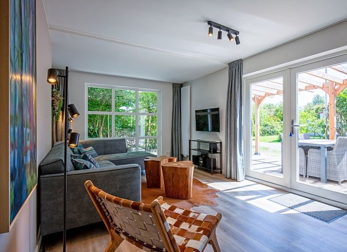 Vacation home D 690 in De Cocksdorp, Texel offers a sunny terrace with wooden pergola, ideal for relaxation on the Wadden Islands.