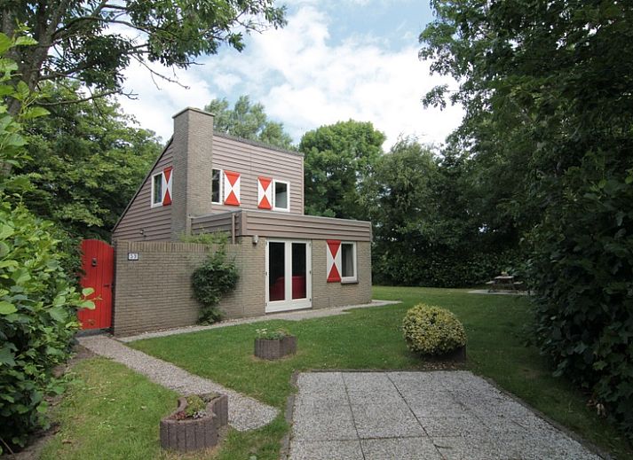 Vakantiehuis B 053 in De Cocksdorp, Texel, omgeven door groene natuur en een uitnodigende tuin, ideaal voor een ontspannen verblijf op de Waddeneilanden.