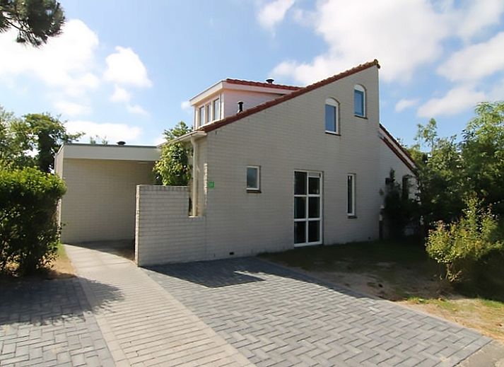 Vakantiehuis D 617 in De Cocksdorp, Texel, biedt een charmante buitenkant met tuinpad en groene omgeving op de Waddeneilanden.