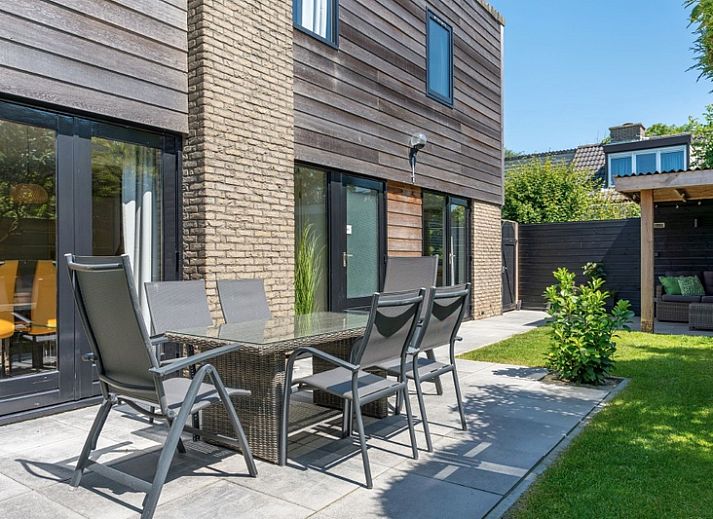 Vakantiehuis A 103 in De Cocksdorp, Texel biedt een serene buitenruimte met groene tuin en uitnodigend terras, ideaal voor ontspanning.