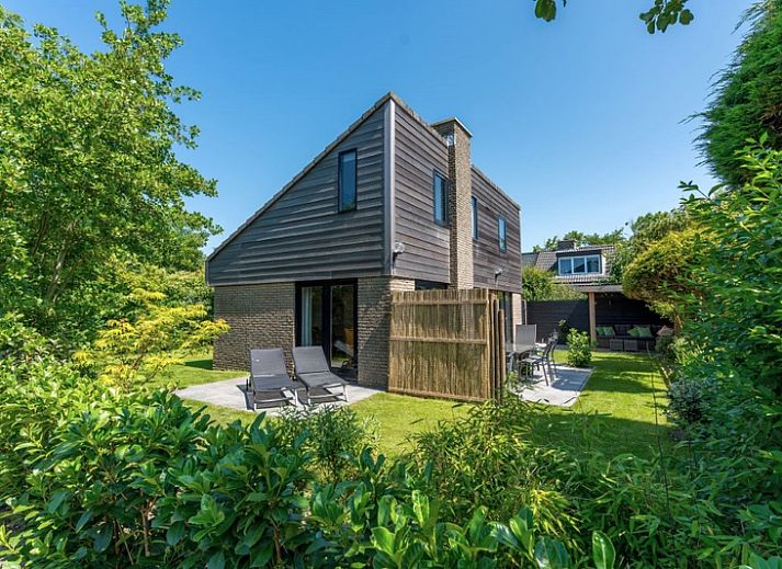 Vakantiehuis A 103 in De Cocksdorp, Texel biedt een serene buitenruimte met groene tuin en uitnodigend terras, ideaal voor ontspanning.