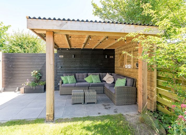 Vakantiehuis A 103 in De Cocksdorp, Texel biedt een serene buitenruimte met groene tuin en uitnodigend terras, ideaal voor ontspanning.