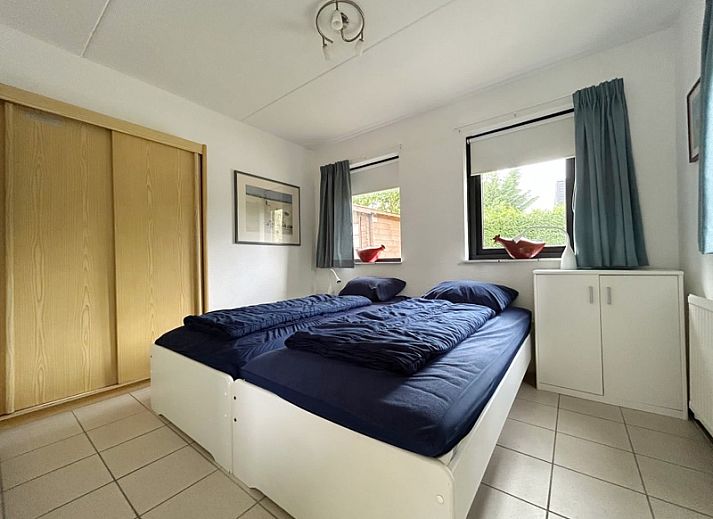 Das Ferienhaus B 203 in De Cocksdorp, Texel, bietet ein charmantes Aeusseres in gruener Umgebung auf den Watteninseln.