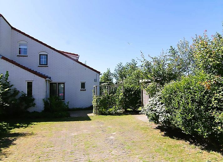 Vakantiehuis D 685 in De Cocksdorp, Texel, biedt een zonnige tuin en groene omgeving, ideaal voor een ontspannen verblijf op de Waddeneilanden.