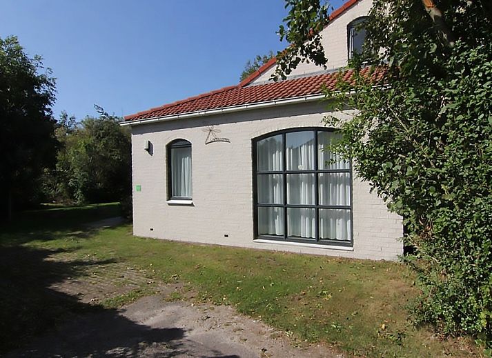 Vakantiehuis D 603 in De Cocksdorp, Texel, biedt een serene buitenruimte met groene tuin en charmante gevel, perfect voor ontspanning.