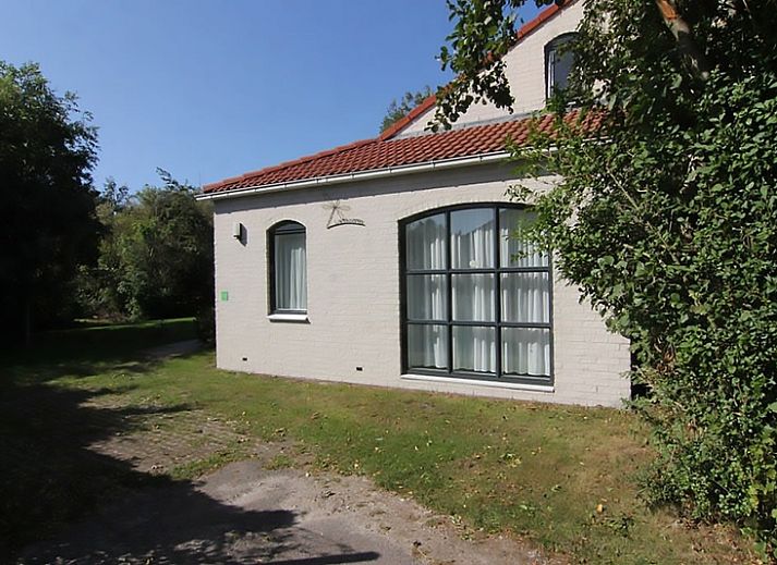 Vakantiehuis D 603 in De Cocksdorp, Texel, biedt een serene buitenruimte met groene tuin en charmante gevel, perfect voor ontspanning.