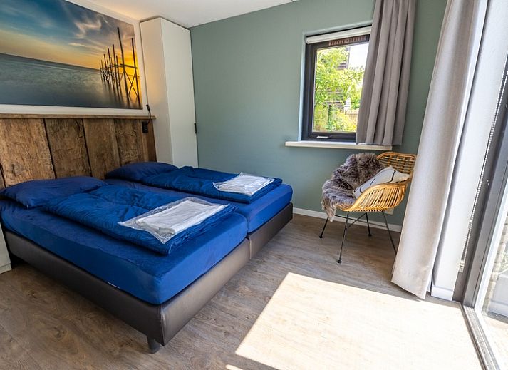 Vakantiehuis A 109 in De Cocksdorp, Texel, omgeven door groene natuur en blauwe lucht, ideaal voor een ontspannen verblijf op de Waddeneilanden.