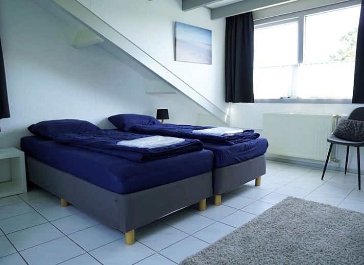 Vakantiehuis A 245 in De Cocksdorp, Texel, biedt een charmante buitenkant met een groene tuin, ideaal voor een ontspannen verblijf op de Waddeneilanden.