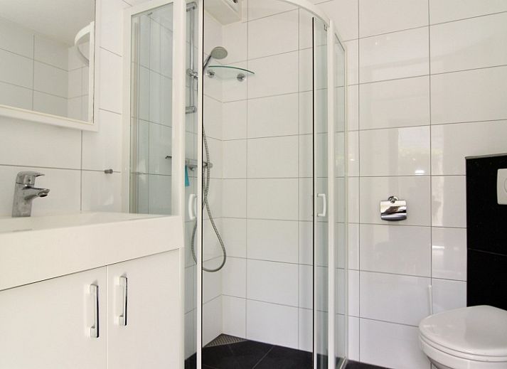 Das Ferienhaus A 381 in De Cocksdorp, Texel, bietet ein modernes Aeusseres mit einer geraeumigen Auffahrt und einer gruenen Umgebung auf den Watteninseln.