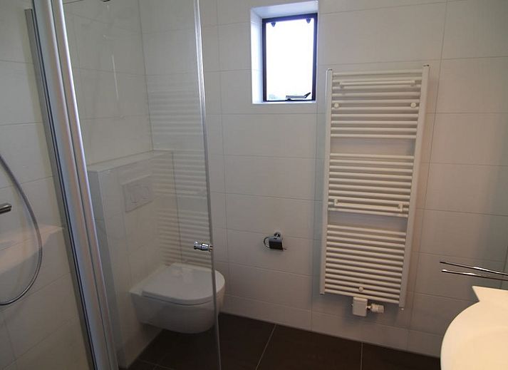 Vakantiehuis D 493 in De Cocksdorp, Texel met ruime oprit en groene haag, perfect voor een ontspannen verblijf op de Waddeneilanden.