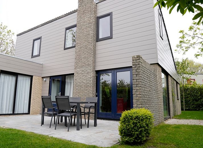 Vakantiehuis C 067 in De Cocksdorp, Texel biedt een charmante buitenkant omgeven door groen, ideaal voor een ontspannen verblijf op de Waddeneilanden.